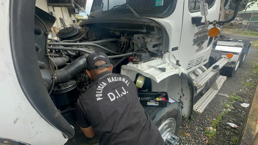Agente de la DIJ inspeccionando el camión recuperado.