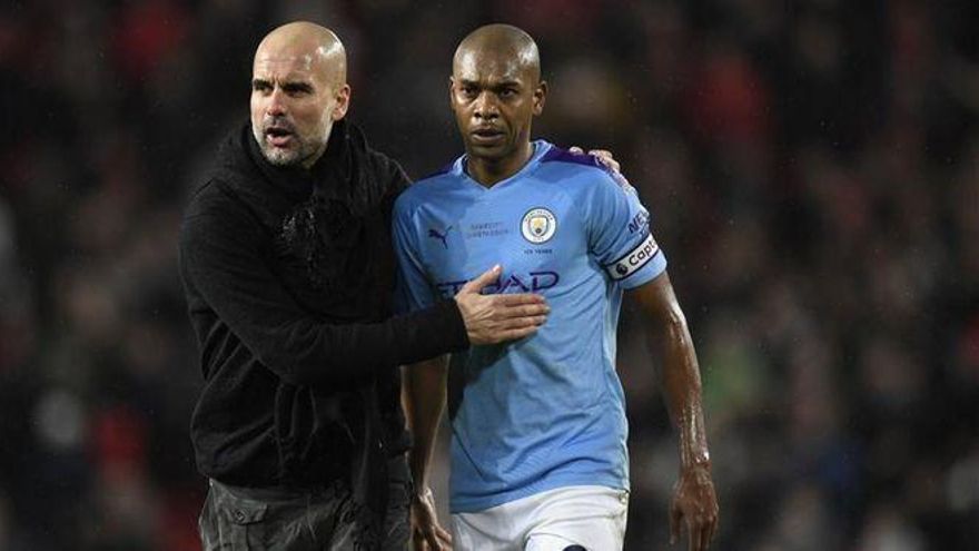 Fernandinho (d) junto al técnico del Manchester City, Pep Guardiola (i)