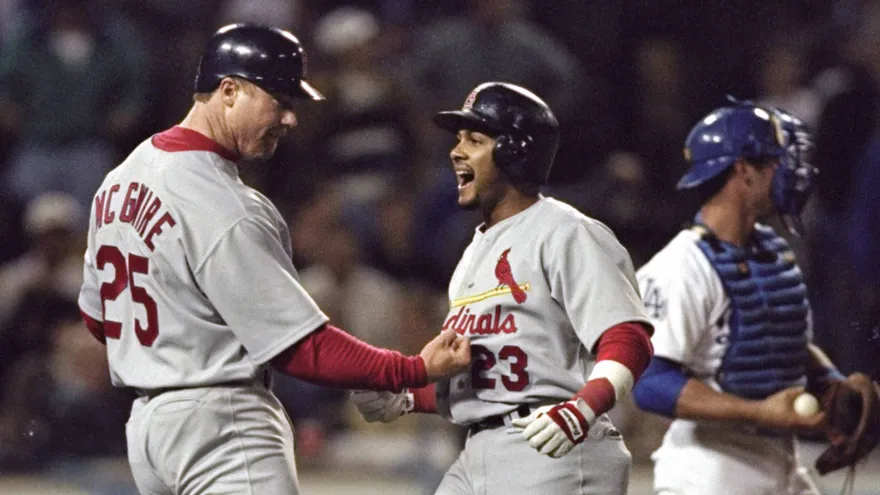 Fernando Tatis padre (d) recibe el saludo de Mark McGwire (i)
