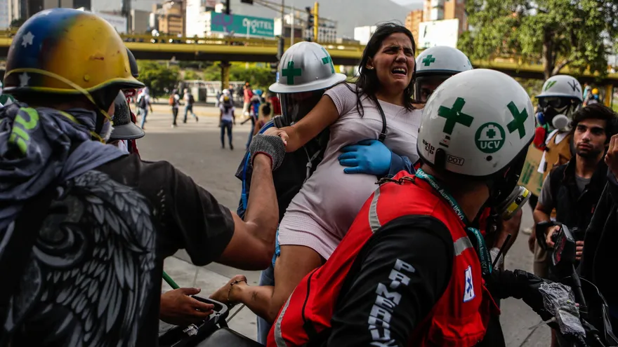 Personal médico auxilia a una persona afectada por los gases lacrimógenos durante el "trancazo" del lunes 10 de julio