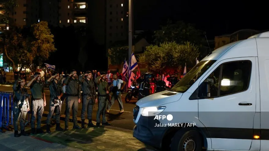 Soldados israelíes saludan mientras los vehículos que transportan los cuerpos de cuatro rehenes entregados tras un acuerdo de alto el fuego e intercambio de prisioneros entre Israel y facciones palestinas en Gaza, llegan al Centro Nacional de Medicina Forense en Tel Aviv el 13 de octubre de 2025.