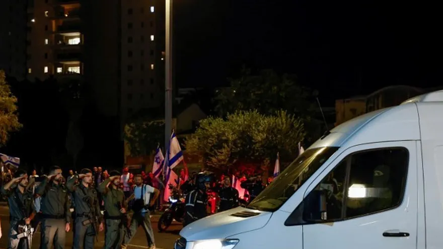 Soldados israelíes saludan mientras los vehículos que transportan los cuerpos de cuatro rehenes entregados tras un acuerdo de alto el fuego e intercambio de prisioneros entre Israel y facciones palestinas en Gaza, llegan al Centro Nacional de Medicina Forense en Tel Aviv el 13 de octubre de 2025.