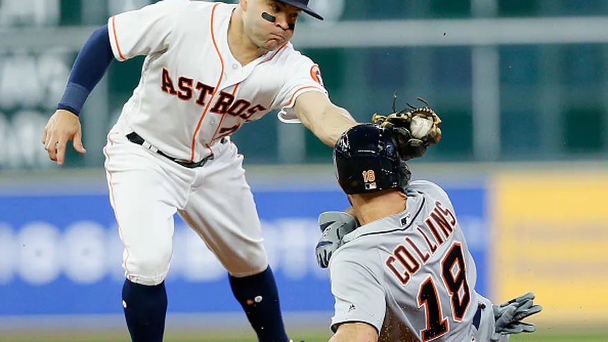 José Altuve (de frente) pone fuera en segunda base a Tyler Collins (18)