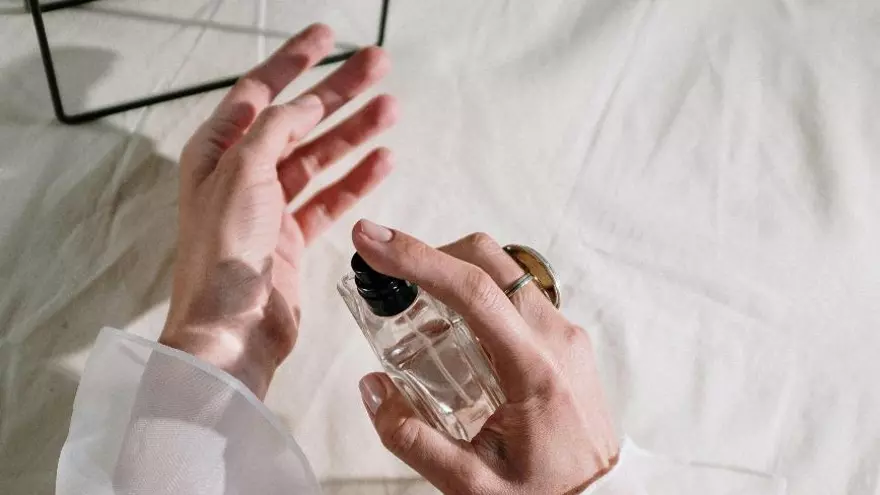 Imagen de una mujer utilizando un perfume. Fines ilustrativos.