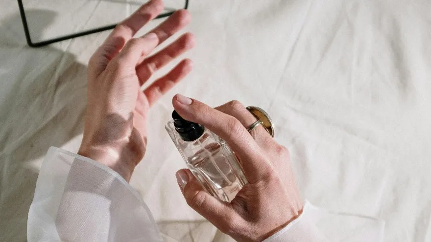 Imagen de una mujer utilizando un perfume. Fines ilustrativos.