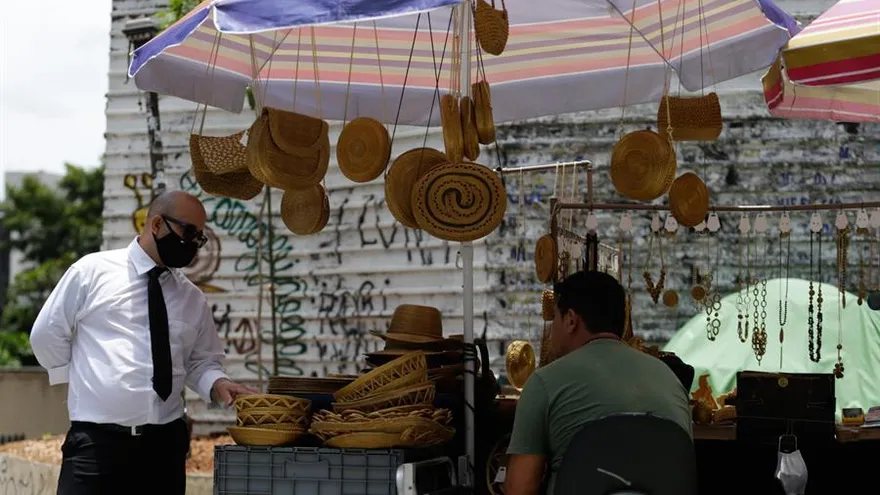 Una persona observa artesanías de un vendedor, Sao Paulo (Brasil).