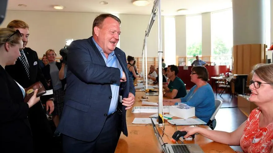 El primer ministro de Dinamarca, el liberal Lars Lokke Rasmussen (c), acude a un colegio electoral para depositar su voto, este miércoles en Copenhague (Dinamarca).