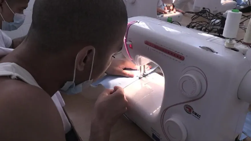 Jóvenes expandilleros cosen mascarillas en Guatemala para enfrentar coronavirus.