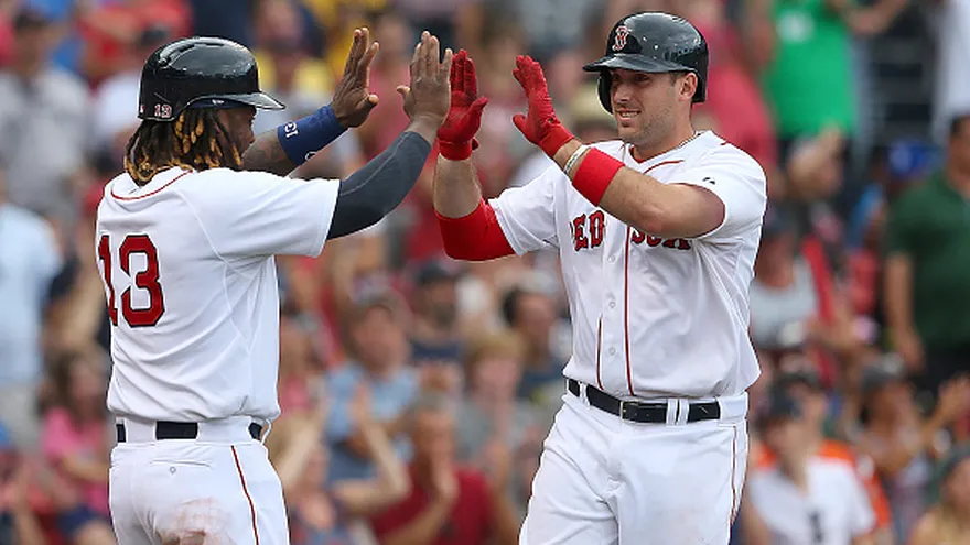 Travis Shaw (de frente) es felicitado por Hanley Ramírez (de espalda)