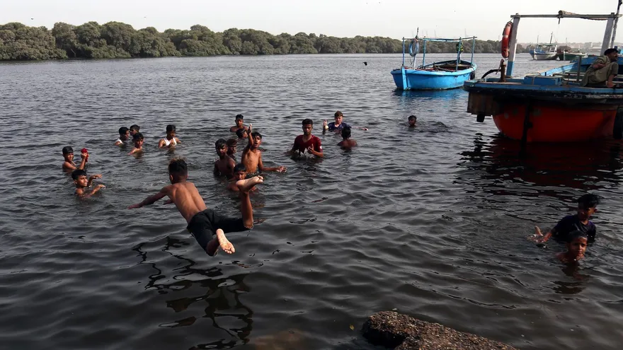 Niños en Pakistán se refrescan por el fuerte calor