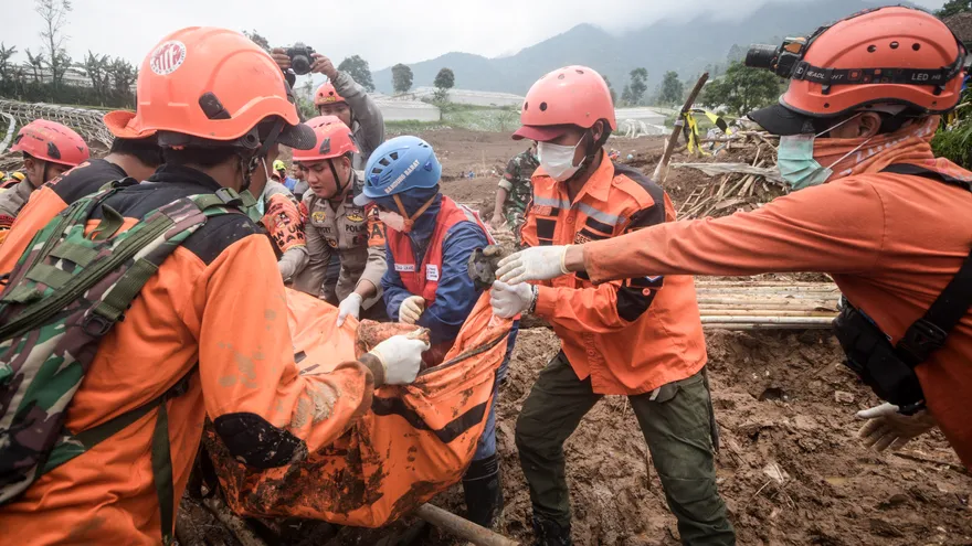 Rescatistas recuperan el cuerpo de una víctima sepultada por un deslizamiento de tierra en la aldea de Pasirlangu en Cisarua, Bandung, Java Occidental, el 26 de enero de 2026. El número de muertos en un masivo deslizamiento de tierra en Indonesia llegó a 17 el 26 de enero, mientras los rescatistas utilizaban equipo pesado para buscar a las docenas de personas que seguían desaparecidas días después de que las fuertes lluvias desataran un torrente de lodo.