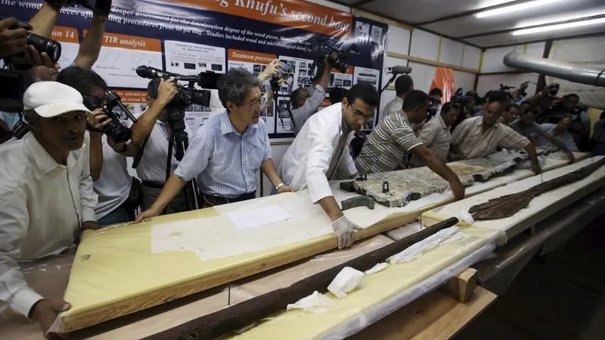 Excavadores y restauradores trabajan en la restauración de una viga de madera que al parecer conformó los remos de la segunda barca solar del faraón Keops en Guiza, Egipto