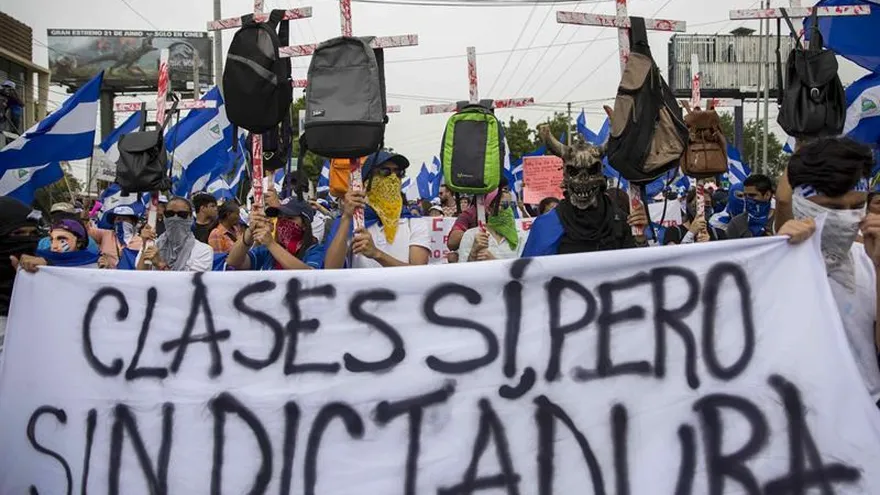 Varios jóvenes con unas cruces con mochilas en honor a los estudiantes que murieron en las pasadas manifestaciones participan en una multitudinaria marcha en apoyo a los estudiantes nicaragüenses y en rechazo al presidente Daniel Ortega, en Managua (Nicaragua).