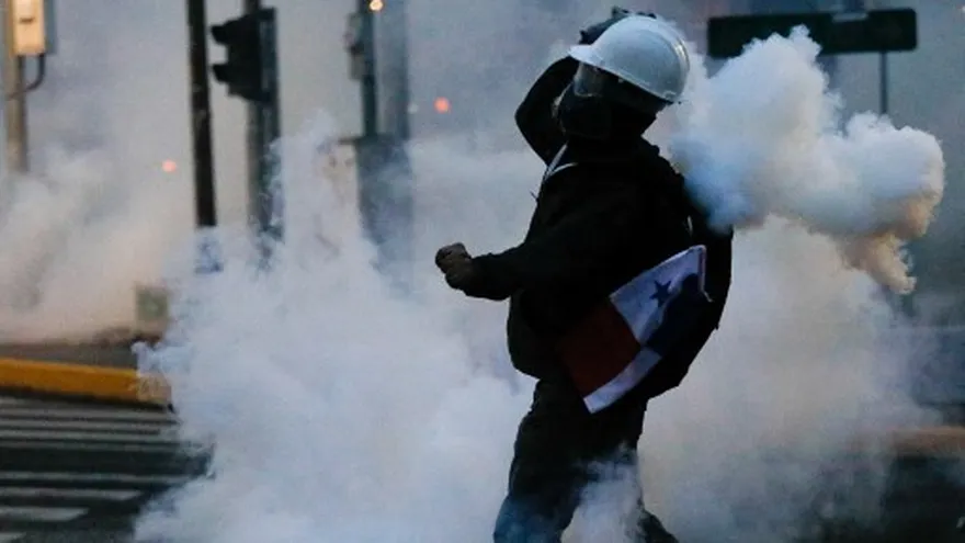 Manifestante en medio de los gases lacrimógenos