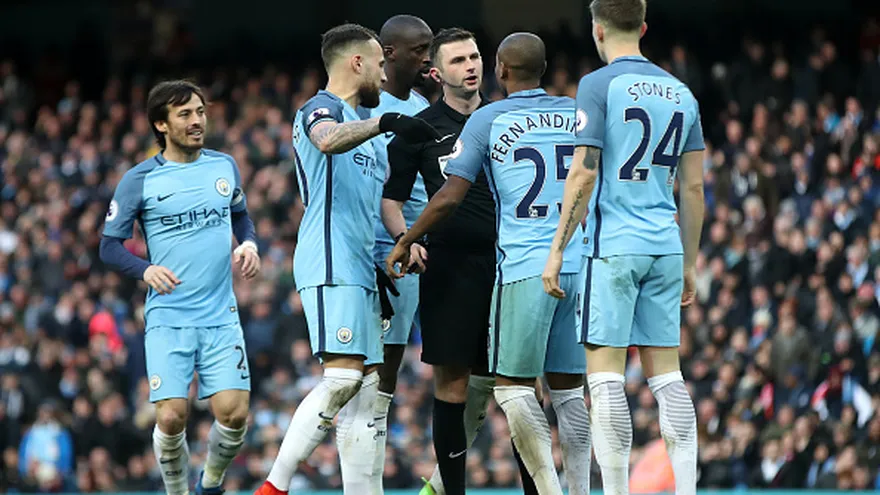 Jugadores del Mánchester City discuten con el árbitro Michael Oliver en el juego ante Liverpool
