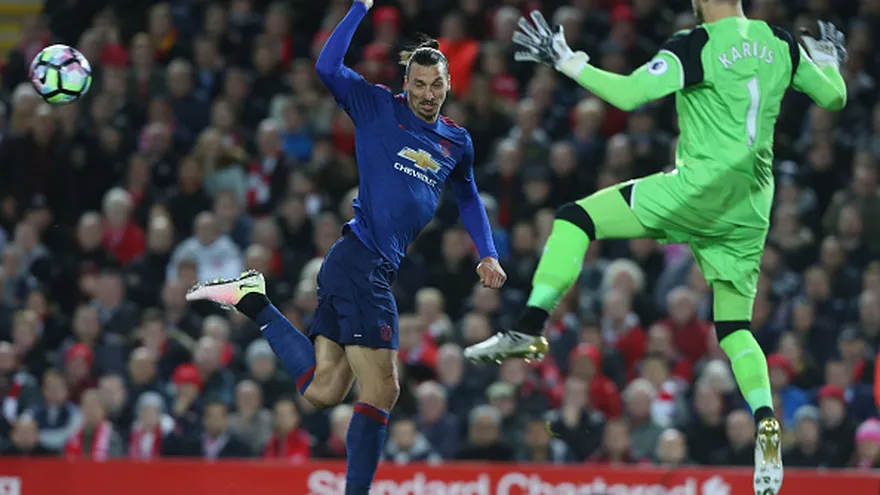 Zlatan Ibrahimvic (de frente) intenta vencer al porterio Loris Karius (de espalda)