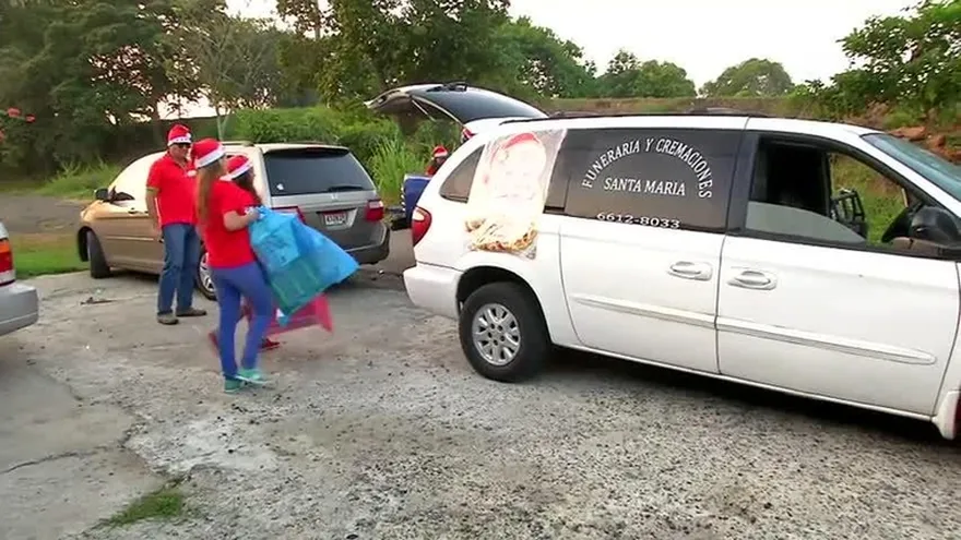 Dueños de funeraria utilizan carroza para transportar obsequios de Navidad