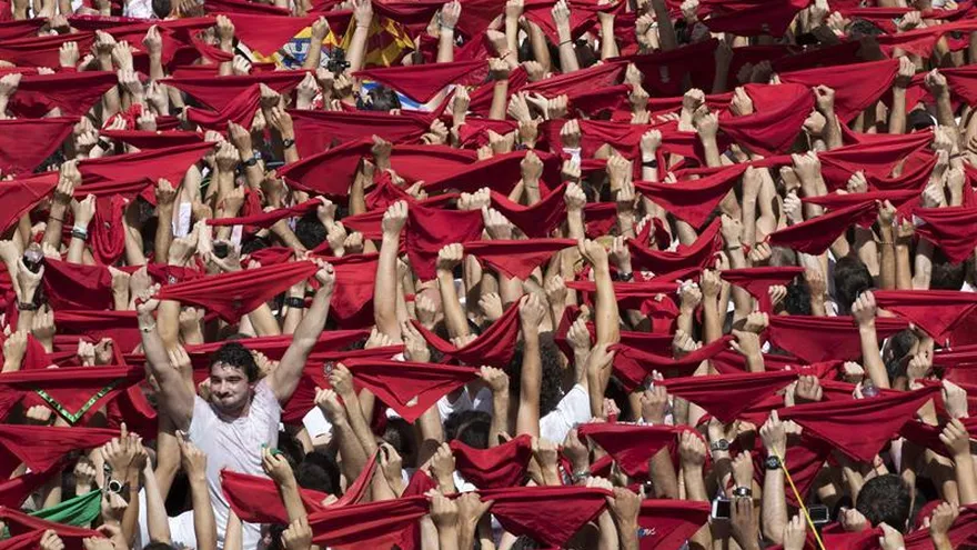 Miles de personas festejan con sus pañuelos rojos alzados el inicio de las fiestas de San Fermín 2017, tras el lanzamiento del tradicional chupinazo desde el balcón del Ayuntamiento de Pamplona.