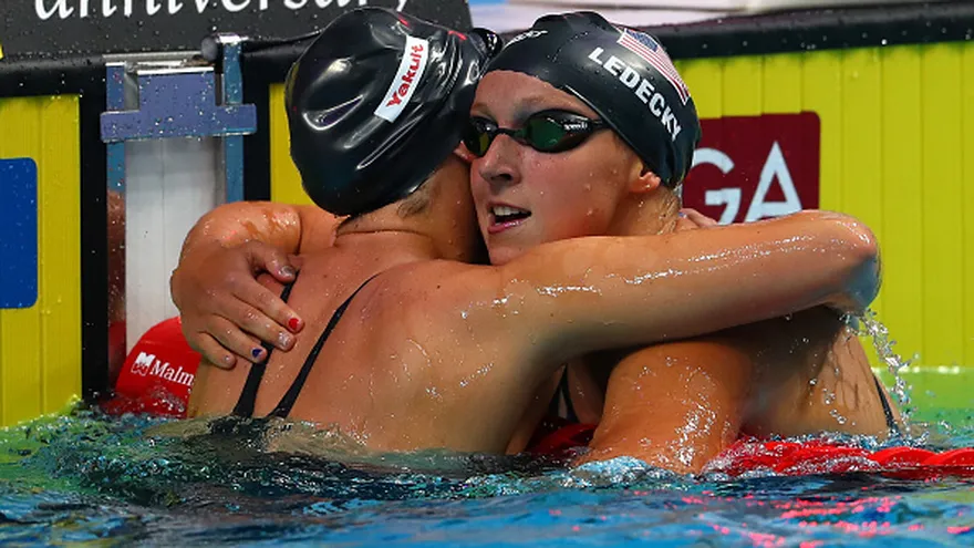 Katie  Ledecky (de frente) abraza a su compatriota Leah Smith (de espalda)