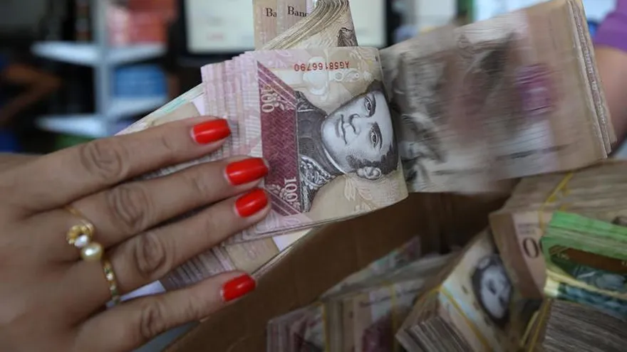 Una mujer que muestra un fajo de bolivares en la ciudad de brasileña de Pacaraima, en la frontera con Venezuela.