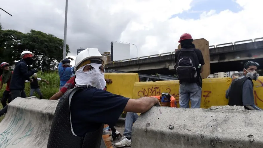Manifestantes de la oposición se preparan para oponerse a las fuerzas del gobierno durante una jornada contra la Asamblea Constituyente que quiere imponer Maduro.