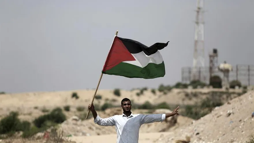 Un hombre fue registrado este martes al enarbolar una bandera palestina junto a una torre de control militar israelí, durante una protesta de Hamás contra las medidas de seguridad en la mezquita de Al Aqsa, en el norte de Beit Lahiya, cerca de la frontera palestino-israelí