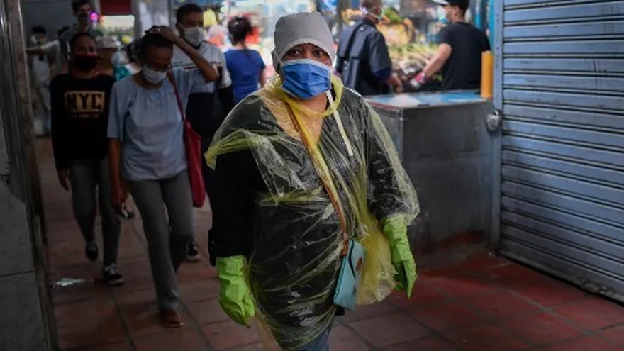 Ciudadanos en Venezuela caminan por una avenida para hacer compras