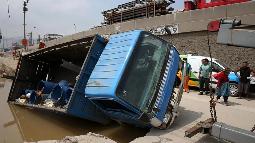 Vista de un camión que cayó a un hueco cubierto de agua por las lluvias en Lima. Perú comienza a recibir y distribuir la ayuda enviada por países como Ecuador, Colombia, Chile y Argentina para enfrentar las consecuencias de las inundaciones, que de momento dejan 75 fallecidos y unos 100.000 damnificados.