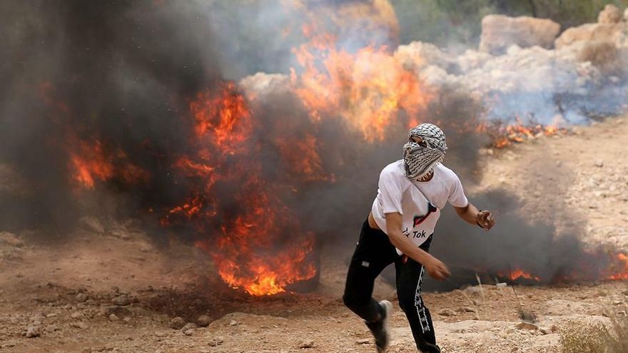 Un manifestante lanza una piedra contra tropas israelíes durante un encontronazo en la ciudad cisjordana de Hebrón, este viernes. Israel reanudó esta noche los bombardeos contra Yihad Islámica en Gaza en represalia por varios ataques con cohetes desde la Franja que el jueves violaron el alto el fuego alcanzado pocas horas antes, lo que pone en cuestión el cese de hostilidades que trajo una calma frágil a la zona.