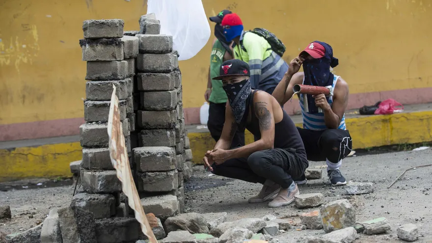 La Policía de Nicaragua libera a 11 manifestantes por gestiones de la CIDH Varios jóvenes se refugian detrás de una barricada de adoquines durante un enfrentamiento con la Policía Nacional el 12 de junio de 2018, en el pueblo de Jinotepe (Nicaragua)