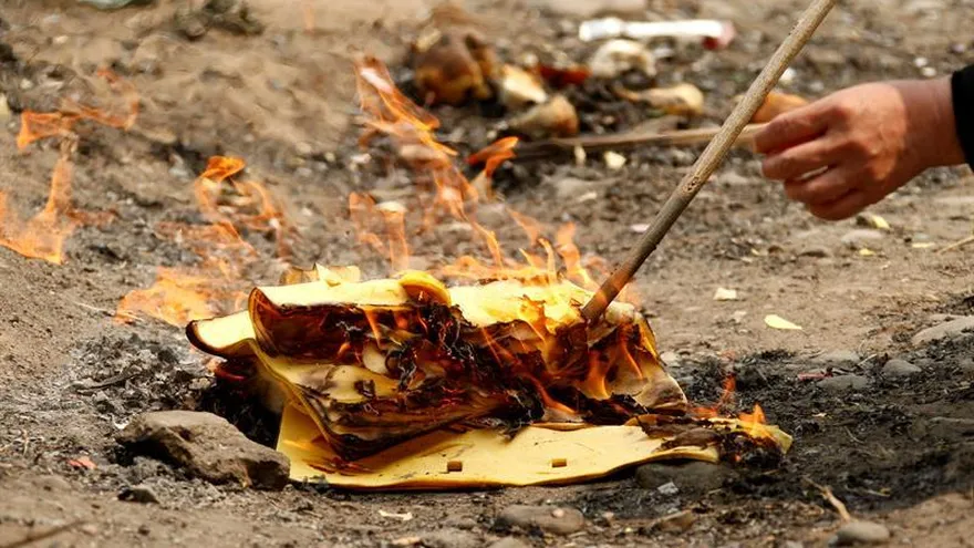 Un hombre quema papel a las afueras de Pekín, China.