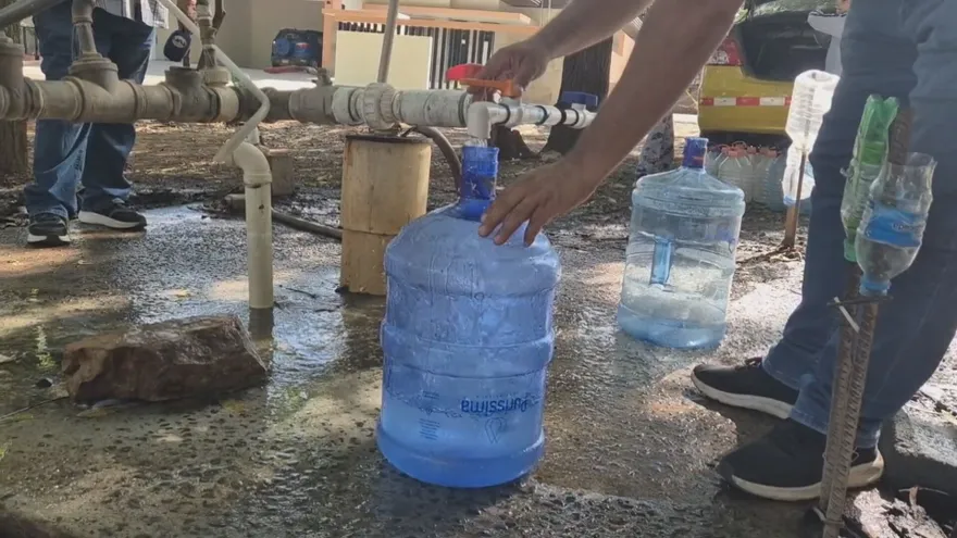 Personas llenando sus envases de agua