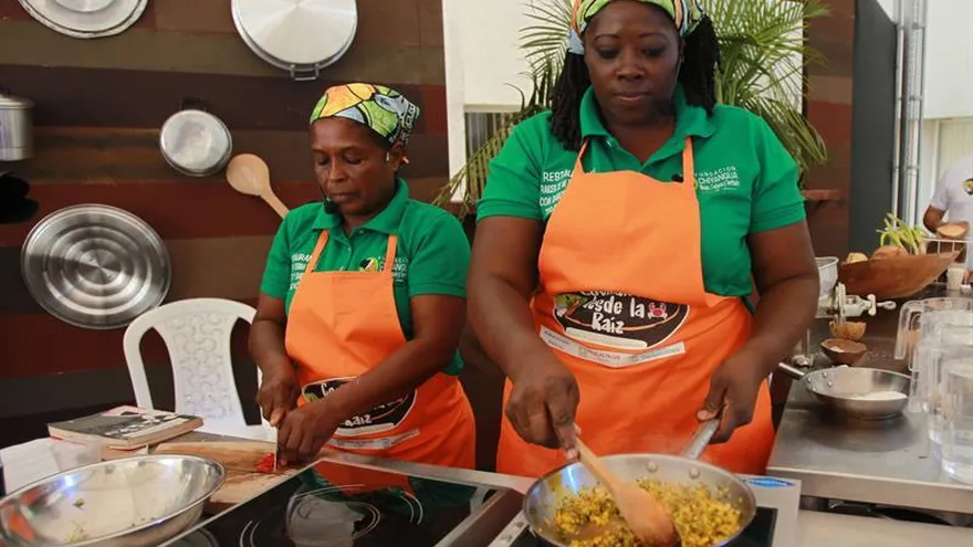 Dos mujeres cocinan durante la edición 28 de encuentro gastronómico "Cocinando desde la Raíz" el pasado viernes, 27 de julio de 2018, con el que el Ministerio de Cultura de Colombia aspira a salvaguardar y mantener las tradiciones de la cocina de la región pacífica, una de las más pobres del país, en Cali (Colombia).