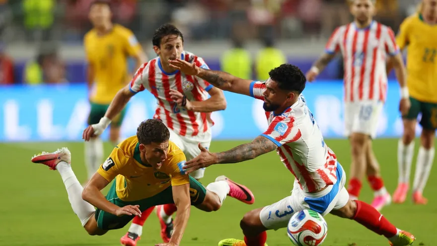 Ajdin Hrustic (al frenre) intenta evadir a Omar Alderete (d) y Matías Galarza (atrás) durante el partido entre Australia y Paraguay