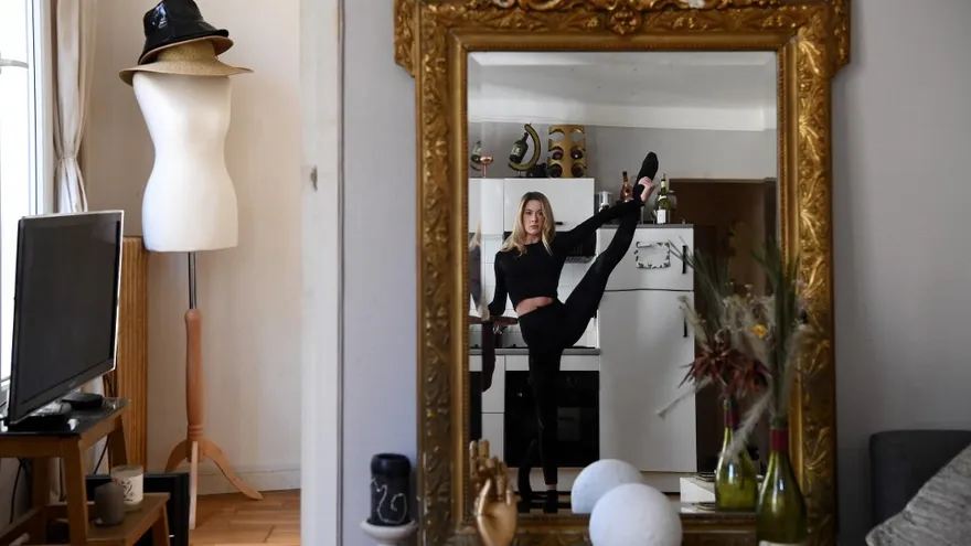 Isabelle, una de las bailarinas del famoso Moulin Rouge, practica en su apartamento de París tras 29 días de estricta cuarentena para mantenerse en forma.