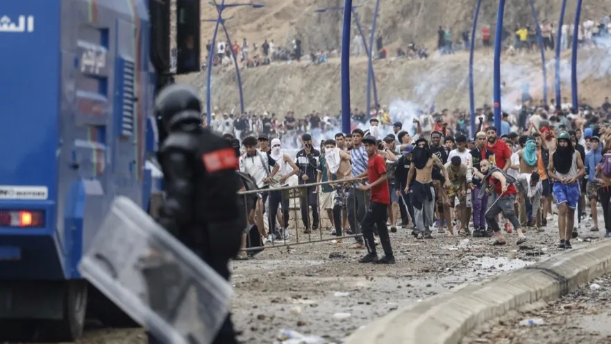 Moroccan security forces clash with migrants attempting to cross into Spain's North African enclave of Ceuta near the town of Fnideq