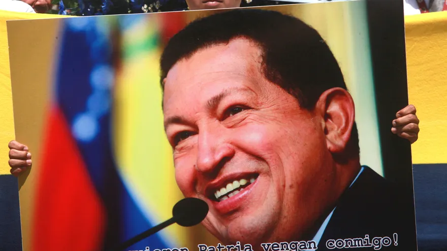 Un joven muestra un cartel con la imagen de Hugo Chávez en Managua (Nicaragua), en aniversario de su fallecimiento