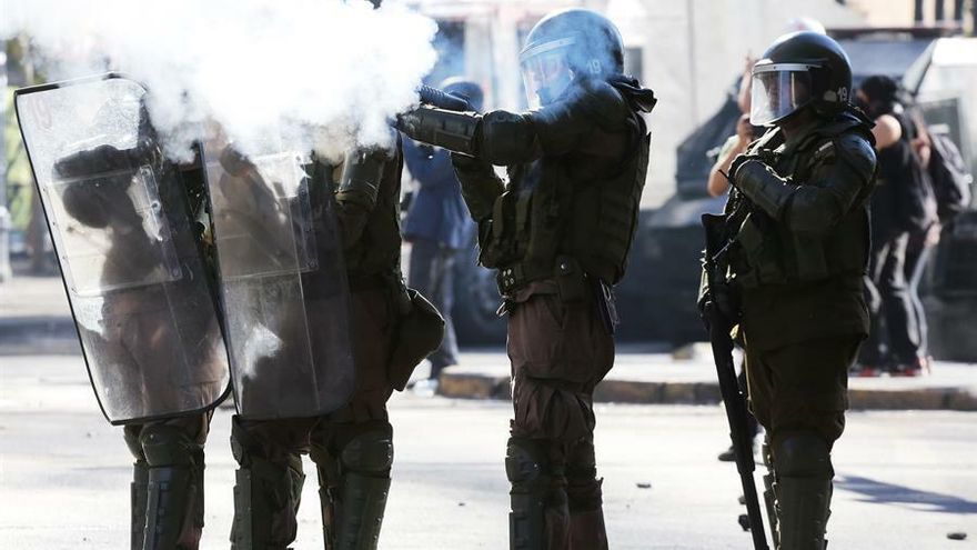 Miembros de la policía disparan bombas lacrimógenas a manifestantes, durante una protesta el pasado 30 de octubre de 2019, en Plaza Italia, en Santiago (Chile)