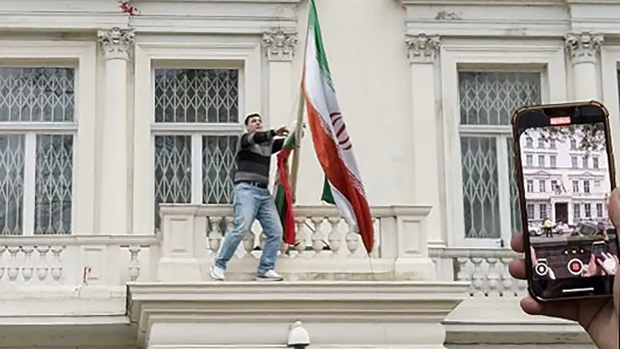 Momento en que un manifestante baja la bandera islámica de Irán y la cambia por la monarquica.