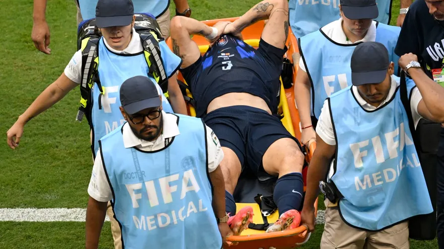 Manuel Ugarte se cubre el rostro mientras es sacado de la cancha en camilla