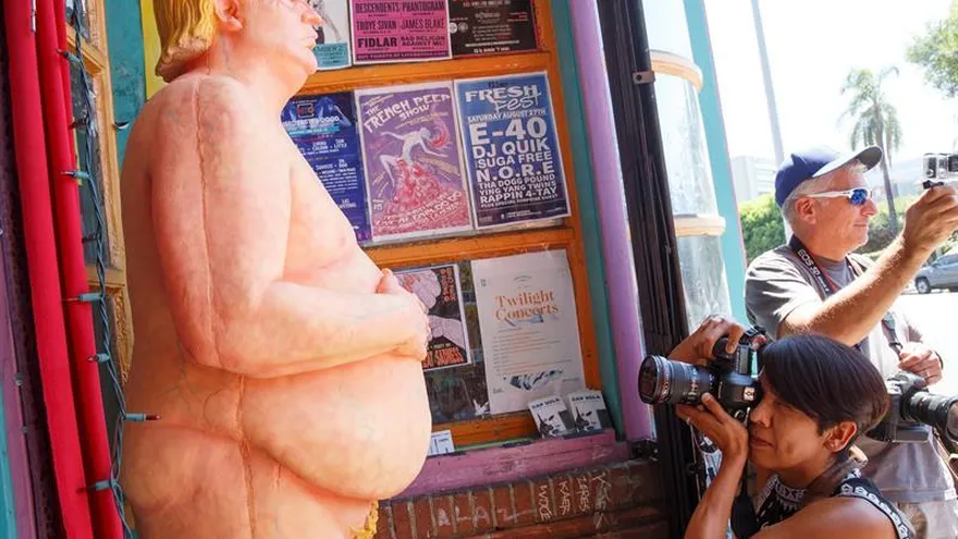 Una estatua desnuda del candidato republicano Donald Trump llama la atención de varios transeúnte hoy, jueves 18 de agosto de 2016, quienes se fotografían con ella, en Los Ángeles (EE.UU.). EFE