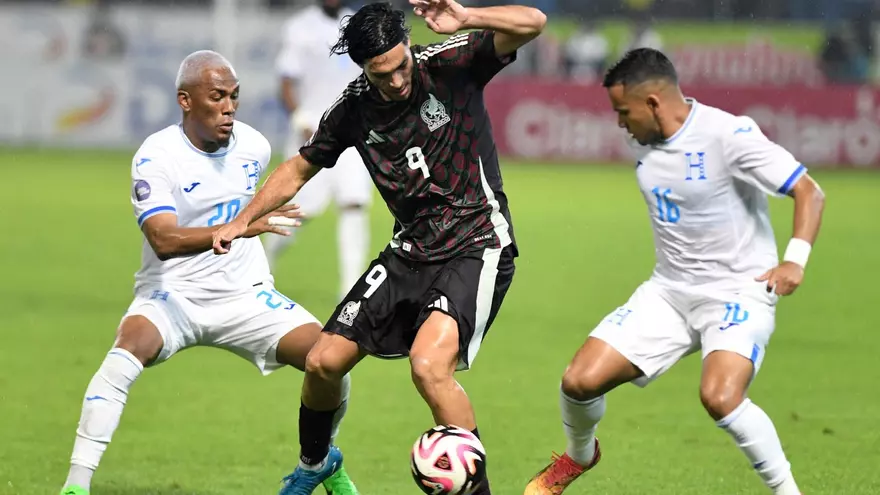 El mexicano Raúl Jiménez (c) trata de evadir la marca de los hondureños Deybi Flores y Edwin Rodríguez