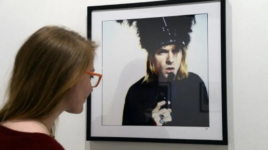 Una mujer observa un retrato de Kurt Cobain