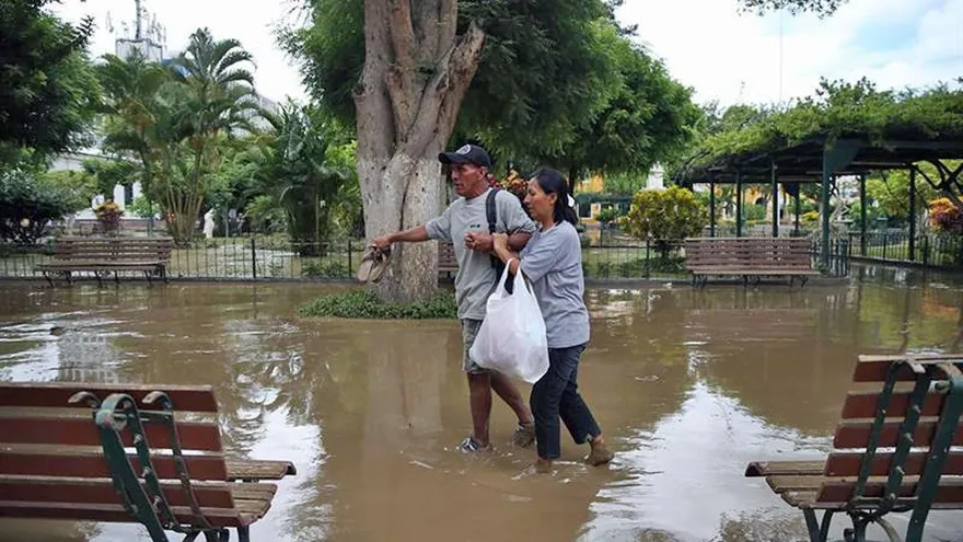 Vista de ayer martes 28 de marzo del 2017, de una pareja caminando en la inundada Plaza de Armas de la ciudad de Piura a unos 1000 kms. al norte de Lima (Perú).