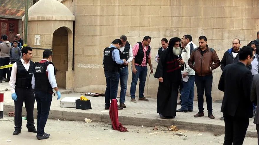 Miembros de las Fuerzas de Seguridad y curiosos congregados en los alrededores de la iglesia Mar Mina tras el ataque contra el templo en el distrito de Heluán, en el sureste de El Cairo (Egipto).