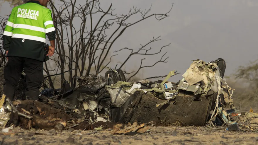 Un agente de policía se encuentra junto a los restos de la avioneta involucrada en un accidente fatal que cobró la vida de sus 13 ocupantes en el distrito de Vista Alegre, Nazca, Perú, el 1 de agosto de 2026.