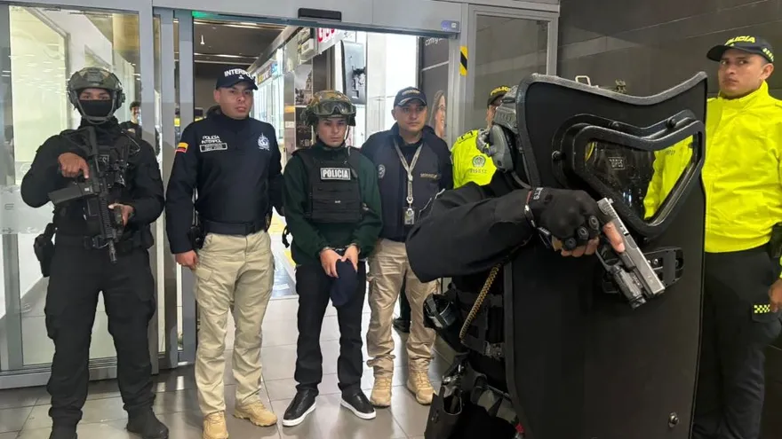 El narco Ángel Aguilar (centro) esposado y custodiado por estamentos de seguridad y migración de Colombia