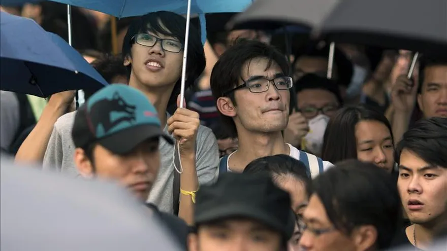 Varios ciudadanos chinos utilizan sus paraguas para resguardarse de la lluvia.