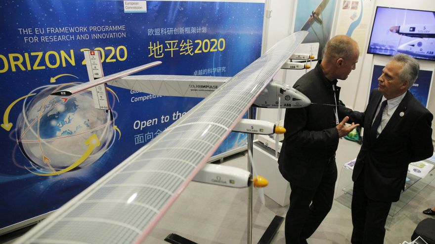 El impulsor y piloto del avión Solar Impulse, Bertrand Picard (i), charla con una persona junto a una maqueta del avión Solar Impulse.