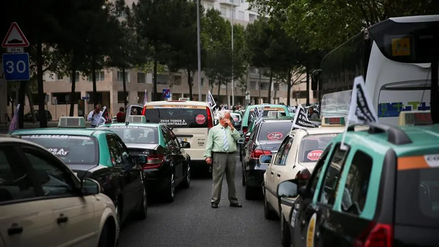 Un taxista permanece junto a sus vehículos durante una manifestación contra la implantación del servicio Uber en Lisboa (Portugal).